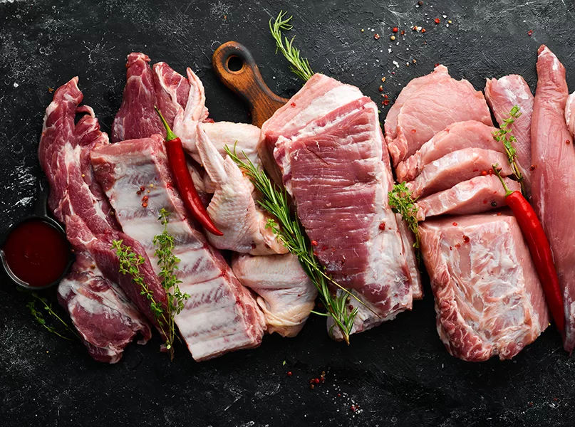 Set of raw meat. Pork meat on black stone background with spices