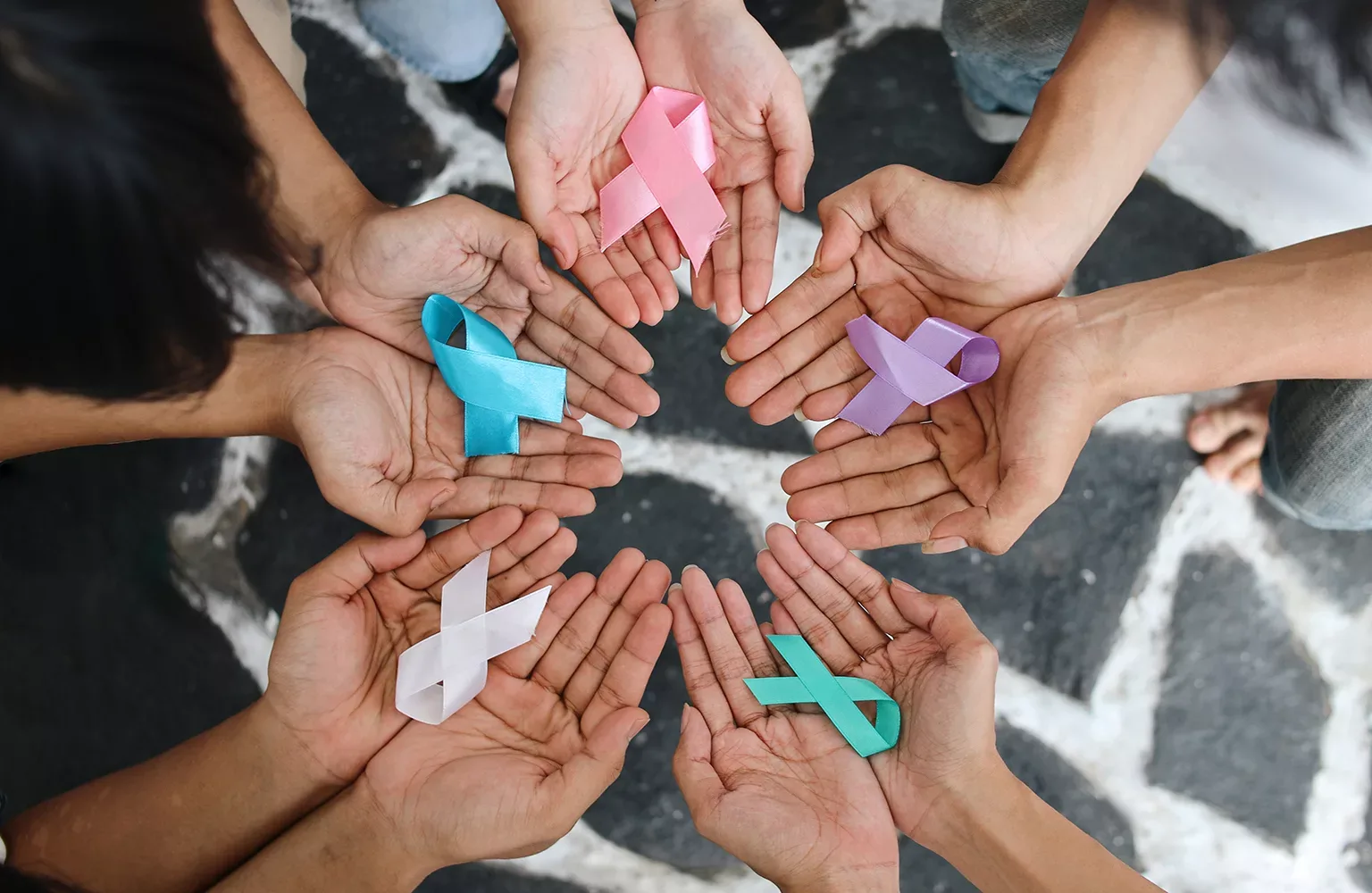 World cancer day. Hands of people holding ribbons
