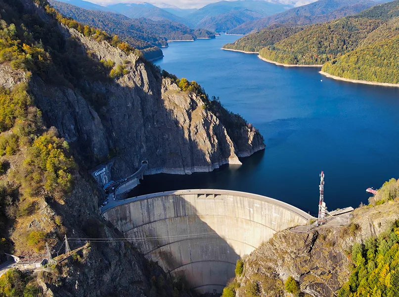Aerial drone view of nature in Romania. Valley in Carpathian mountains with Vidraru dam and lake, slopes with lush forest