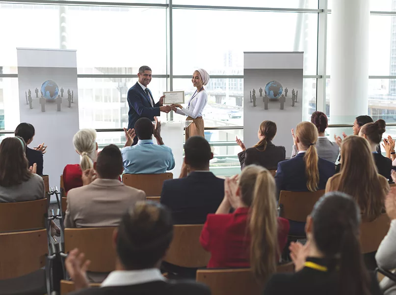 Businesswoman receiving award from businessman