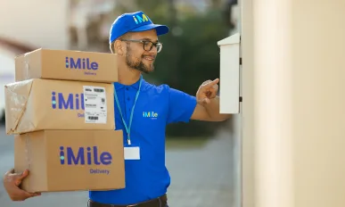 Happy deliverer reading data on a mailbox